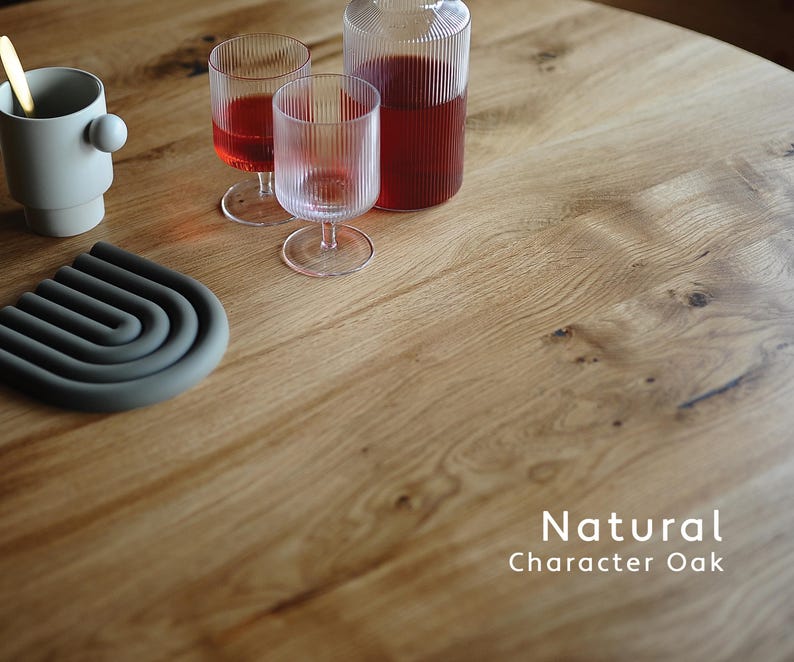 Puede incluir: Una superficie de mesa de roble natural con una taza beige claro con un detalle esf&eacute;rico lateral, dos vasos de vidrio estriado, una jarra de vidrio estriado con l&iacute;quido rojo y un salvamanteles de silicona gris oscuro con el texto Natural Character Oak.