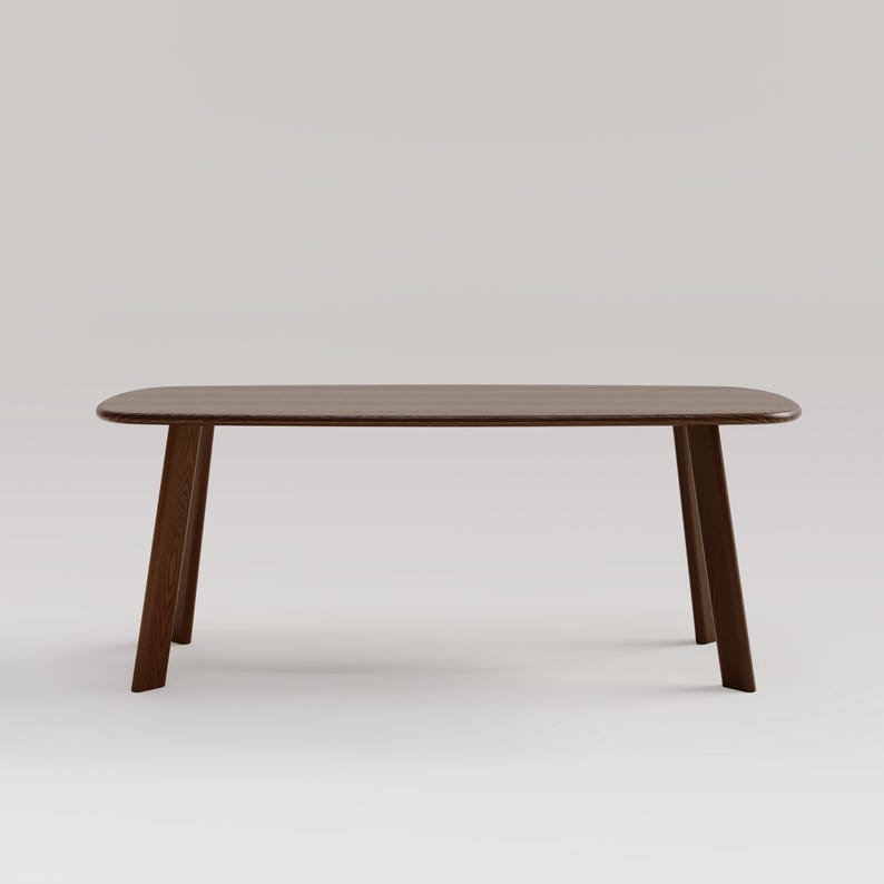 May include: A dark brown wooden table with a rectangular top and angled legs. The table has a smooth, polished surface and a minimalist design. The table is approximately 60 inches long.