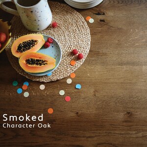 Puede incluir: Una superficie de madera marr&oacute;n con el texto Smoked Character Oak impreso en blanco. La superficie presenta un mantel individual redondo de yute trenzado con un plato azul claro moteado con dos mitades de papaya y frambuesas, una taza y un cuenco amarillo.