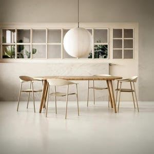 May include: A light-colored wooden dining table with four matching chairs featuring curved backrests and thin legs. A large, spherical white paper pendant light hangs directly above the center of the table, illuminating the furniture set.