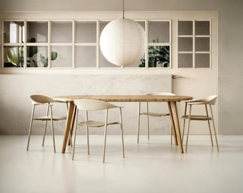 May include: A light-colored wooden dining table with four matching chairs featuring curved backrests and thin legs. A large, spherical white paper pendant light hangs directly above the center of the table, illuminating the furniture set.