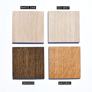 Op de afbeelding: Vier vierkante houtmonsters gerangschikt in een raster. Linksboven is White Oak, een lichtbruin hout. Rechtsboven is Sea Mist, een bleek gebroken wit hout. Linksonder is Smoked, een donkerbruin hout. Rechtsonder is Natural, een warm goudbruin hout.