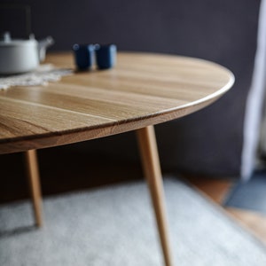 Round dining table made from reclaimed oak wood with a shark edge in natural on danish tapered legs. Fully customisable to your needs