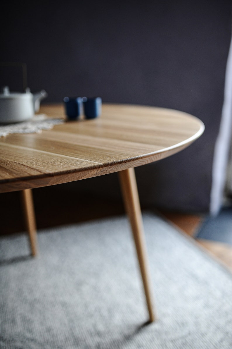 Round dining table made from reclaimed oak wood with a shark edge in natural on danish tapered legs. Fully customisable to your needs