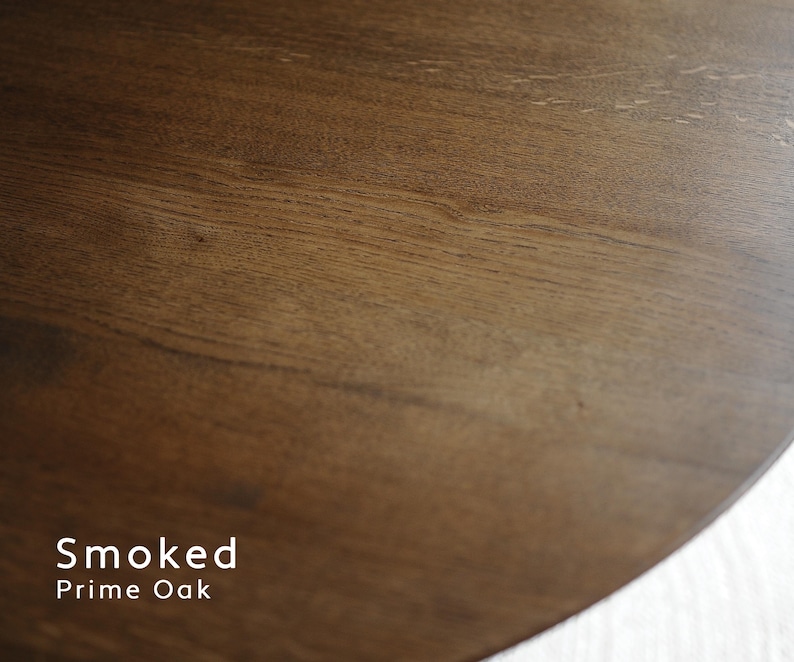 May include: Close-up of a section of a wooden surface with a rich, dark brown color and visible wood grain. The text "Smoked Prime Oak" is displayed in white at the bottom left of the image. The wood has a smooth, polished appearance.