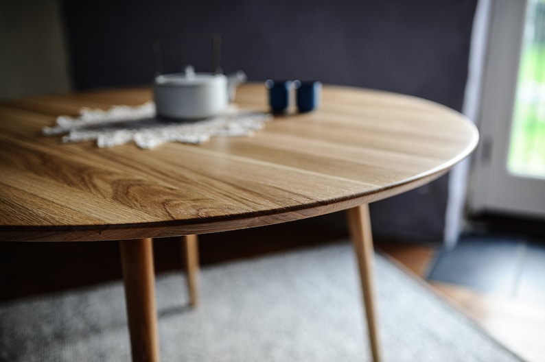 Round dining table made from reclaimed oak wood with a shark edge in natural on danish tapered legs. Fully customisable to your needs