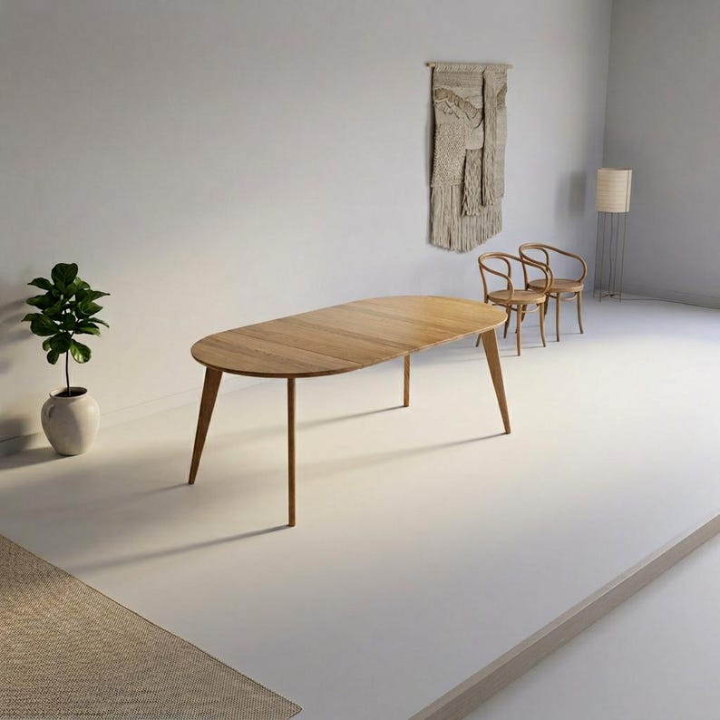 May include: An oval wooden dining table with a light brown finish and four tapered legs. The table surface features a visible wood grain pattern. The design is simple and functional, providing a flat, smooth top for dining or other activities.