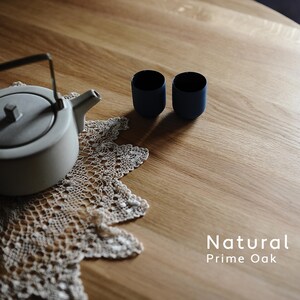 Puede incluir: Una tetera gris claro con asa y boquilla negras se encuentra sobre un tapete de encaje color crema. Dos tazas peque&ntilde;as de color azul oscuro est&aacute;n junto a la tetera. El texto "Natural Prime Oak" est&aacute; en la esquina inferior derecha.