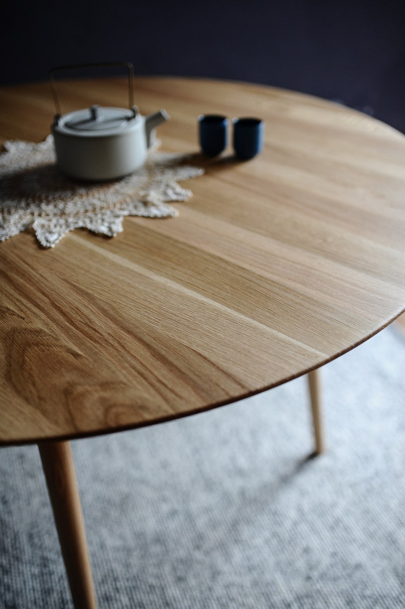 Round dining table made from reclaimed oak wood with a shark edge in natural on danish tapered legs. Fully customisable to your needs