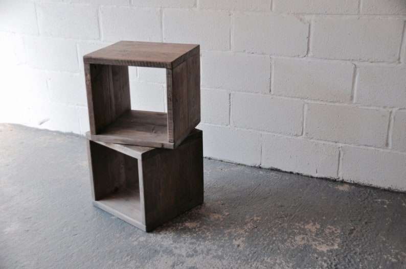 May include: Two wooden cube shelves stacked on top of each other. The shelves are made of reclaimed wood and have a rustic finish. The shelves are empty.