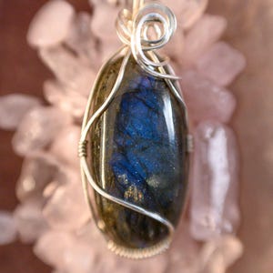 May include: A silver wire wrapped pendant featuring a blue and grey labradorite gemstone.