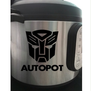 May include: A silver Instant Pot with a black Transformers Autobot logo and the text "AUTOPOT" on the front.