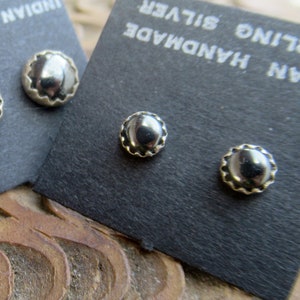 May include: Three pairs of silver stud earrings on black cards. Each card reads "Indian Handmade Sterling Silver".