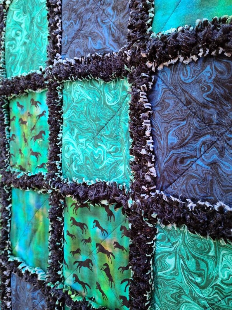 Close-up perspective of the quilted squares, emphasizing the texture of the dark frayed rag edges between panels.