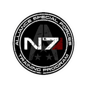 Puede incluir: Un emblema circular con el texto "ALLIANCE SPECIAL FORCES TRAINING PROGRAM" en blanco desgastado. El centro presenta un diseño estilizado "N7" en blanco, con un acento rojo, y tres estrellas sobre fondo negro.