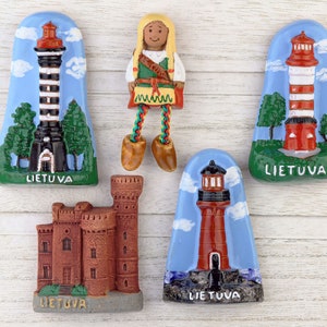 Peut inclure: Cinq aimants de réfrigérateur colorés représentant des images de phares et une personne vêtue de vêtements traditionnels lituaniens. Les aimants sont tous rectangulaires et portent l'inscription "LIETUVA", qui signifie "Lituanie" en lituanien.