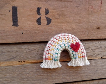 Rainbow brooch in felt and macramé embroidered by hand with a small red heart