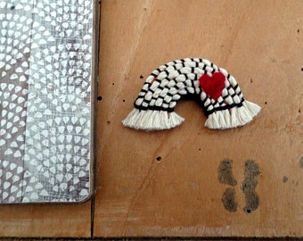 Rainbow brooch in felt and macramé embroidered by hand with a small red heart