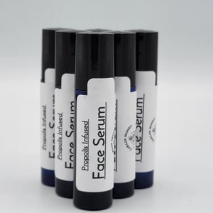 May include: Six black roll-on bottles with white labels. The labels say "Propolis Infused Face Serum" and "Carlin Honey".