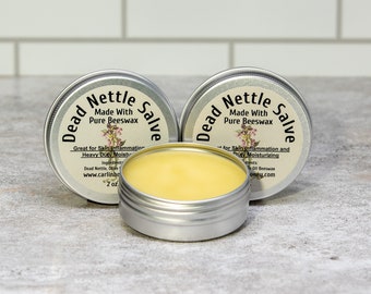 May include: Three silver tins of Dead Nettle Salve, made with pure beeswax. Each tin has a label with the product name, ingredients, and website address. The salve is great for skin inflammation and heavy duty moisturizing.