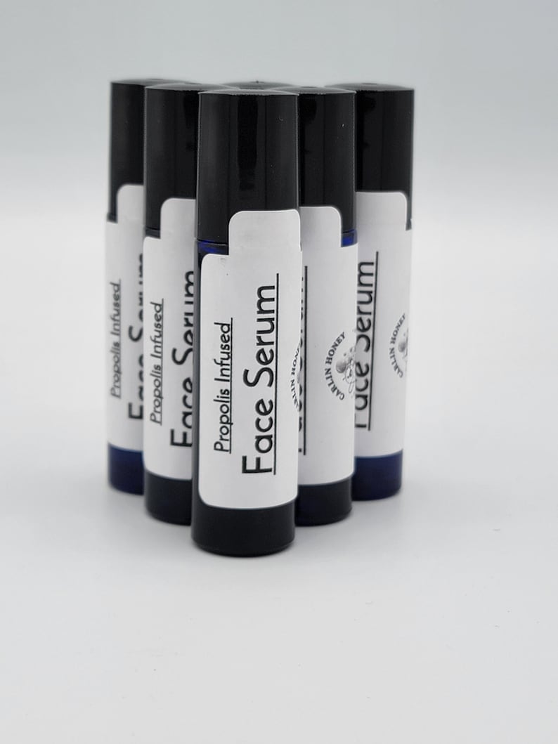 May include: Six black roll-on bottles with white labels. The labels say "Propolis Infused Face Serum" and "Carlin Honey".