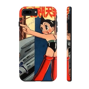 May include: A black phone case with a retro illustration of Astro Boy, a Japanese manga character, pointing with his right hand. The case features the Japanese text "鉄腕アトム" (Tetsuwan Atomu) which is the Japanese name for Astro Boy.