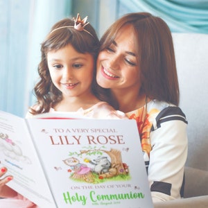 Op de afbeelding: Een wit boek met een kleurrijke illustratie van bosdieren. Het boek zegt "To a very special Lily Rose on the day of your Holy Communion 10th August 2019".