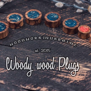 May include: A collection of wooden plugs with decorative tops. Some plugs have blue and white marbled designs, while others feature red and orange patterns. The image includes the text "Woodwork in Ukraine" and "Woody wood Plugs."