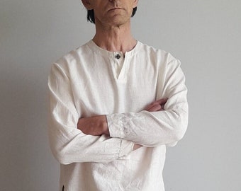 May include: A white long-sleeved shirt with a button-up collar and a single button at the neck. The shirt is made of a lightweight fabric and has a relaxed fit.