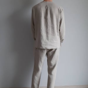 May include: A beige linen pajama set with long sleeves and pants. The set is made of a soft, breathable fabric and is perfect for lounging around the house.