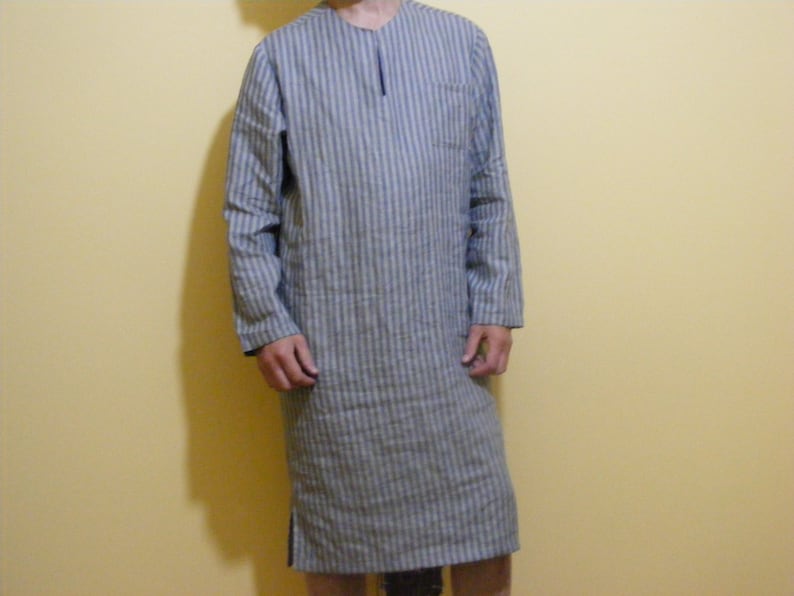 May include: A long-sleeved shirt with a striped pattern in blue and white. The shirt has a collar and a button-up front.