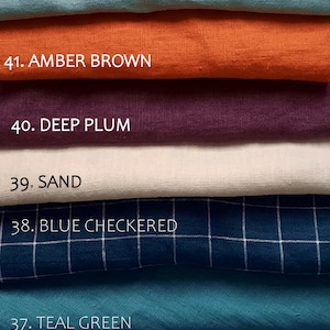 May include: A stack of fabric swatches in various colors, including mint green, amber brown, deep plum, sand, blue checkered, teal green, and light blue. Each swatch is labeled with a number and color name.