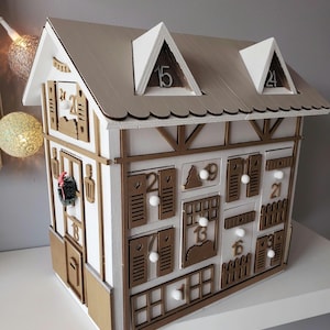 Calendario de Adviento de Madera – Casita de Chalet Dorada y Blanca – Decoración Navideña Reutilizable Hecha a Mano – Idea de Regalo Navideño Original