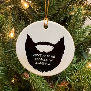 May include: White ceramic Christmas bauble with a black silhouette of a beard and the text "Don't hate me because I'm beardful".
