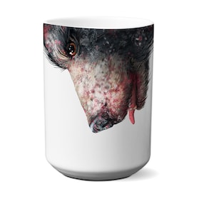 Puede incluir: Taza de cerámica blanca con una ilustración en blanco y negro de la cara de un perro. La cara del perro es parcialmente visible, con la nariz y la boca en foco. El pelaje del perro es blanco y negro, y sus ojos son marrones.