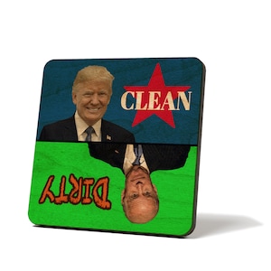 May include: A square wooden sign with a blue and green background. The top half of the sign features a red star with the word "CLEAN" in white text. The bottom half of the sign features the word "DIRTY" in orange text. A portrait of Donald Trump is on the top half of the sign, and a portrait of Joe Biden is on the bottom half of the sign, upside down.