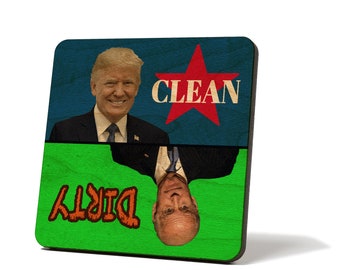 May include: A square wooden sign with a blue and green background. The top half of the sign features a red star with the word "CLEAN" in white text. The bottom half of the sign features the word "DIRTY" in orange text. A portrait of Donald Trump is on the top half of the sign, and a portrait of Joe Biden is on the bottom half of the sign, upside down.