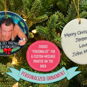 Op de afbeelding: Twee ronde witte kerstballen van keramiek. E&eacute;n kerstbal heeft een foto van Bruce Willis uit de film Die Hard met de tekst "We'll get together have a few laughs". De andere kerstbal heeft de tekst "Merry Christmas Jeremy Love, John McClane".