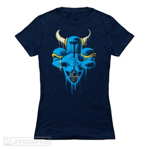May include: A navy blue t-shirt with a blue and yellow graphic of a knight holding a sword. The graphic is in a spray paint style and the text "For Shovelry" is below the knight.