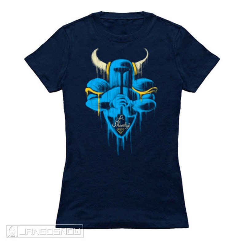 May include: A navy blue t-shirt with a blue and yellow graphic of a knight holding a sword. The graphic is in a spray paint style and the text "For Shovelry" is below the knight.