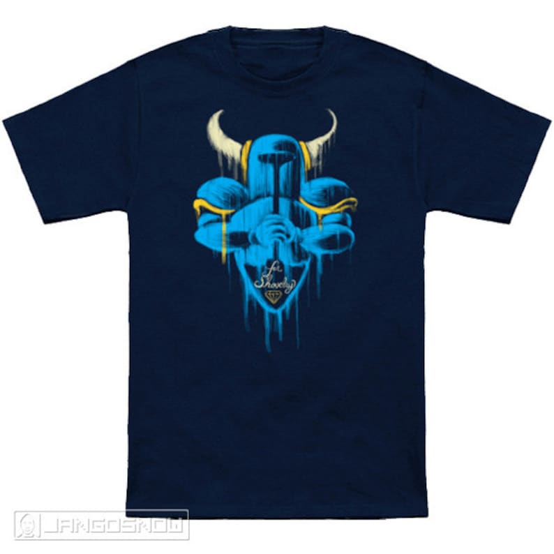 May include: A navy blue t-shirt with a blue and yellow graphic of a knight holding a sword. The graphic is dripping with paint and has the text "For Shovelry" with a diamond.