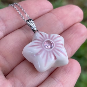 May include: A set of three ceramic mugs with a speckled, matte finish. The mugs are in shades of cream, light gray, and dark gray. Each mug has a simple, minimalist design and a rounded handle.