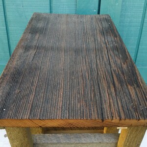 Puede incluir: Una mesa de madera r&uacute;stica con una tapa de color marr&oacute;n oscuro y una base de color marr&oacute;n claro. La mesa est&aacute; hecha de madera recuperada y tiene un aspecto &uacute;nico y desgastado.
