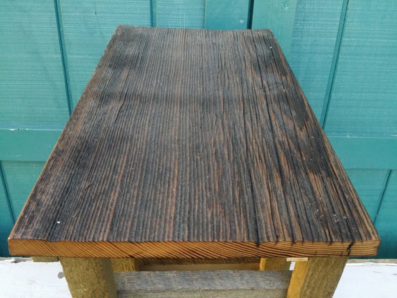 Puede incluir: Una mesa de madera r&uacute;stica con una tapa de color marr&oacute;n oscuro y una base de color marr&oacute;n claro. La mesa est&aacute; hecha de madera recuperada y tiene un aspecto &uacute;nico y desgastado.