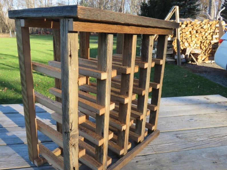 Puede incluir: Estante de vino de madera r&uacute;stica con acabado natural. El estante tiene varios estantes y est&aacute; hecho de madera recuperada.