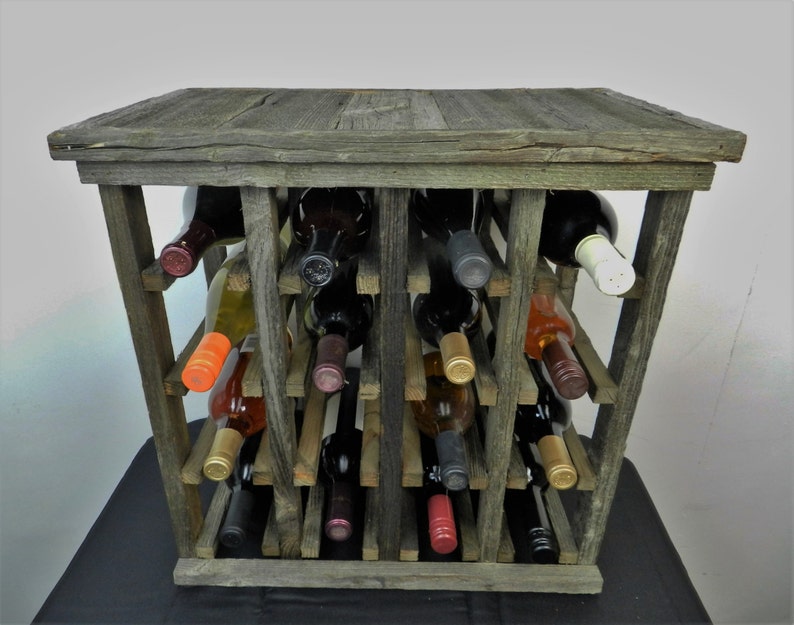 Puede incluir: Un estante de vino de madera r&uacute;stico con un acabado gris desgastado. El estante contiene varias botellas de vino, incluyendo tinto, blanco y rosado.
