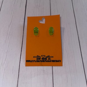 Puede incluir: Un par de pendientes de cactus verdes en una tarjeta naranja con el texto "Shop Online At: www.etsy.com/shop/ZARAStonecraft"