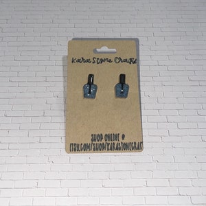 May include: A pair of blue glitter nail polish bottle earrings on a brown card with the text "Kara Stone Crafts" and "Shop Online etsy.com/shop/karastonecrafts".