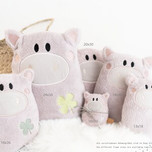 Puede incluir: Cinco almohadas de cerdo rosa de peluche de diferentes tama&ntilde;os con dise&ntilde;os de tr&eacute;bol y coraz&oacute;n bordados. Las almohadas est&aacute;n etiquetadas con sus dimensiones en pulgadas: 24x36, 20x30, 18x30, 13x18 y 10x10.