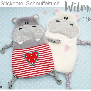 Puede incluir: Dos juguetes de peluche de hipopótamo, uno gris con rayas rojas y blancas y un corazón rojo con estrellas blancas, y otro blanco con un corazón rosa. El hipopótamo gris está etiquetado como "Wilma" y el texto "18x30" es visible. Los juguetes están sobre un fondo azul con lunares blancos.